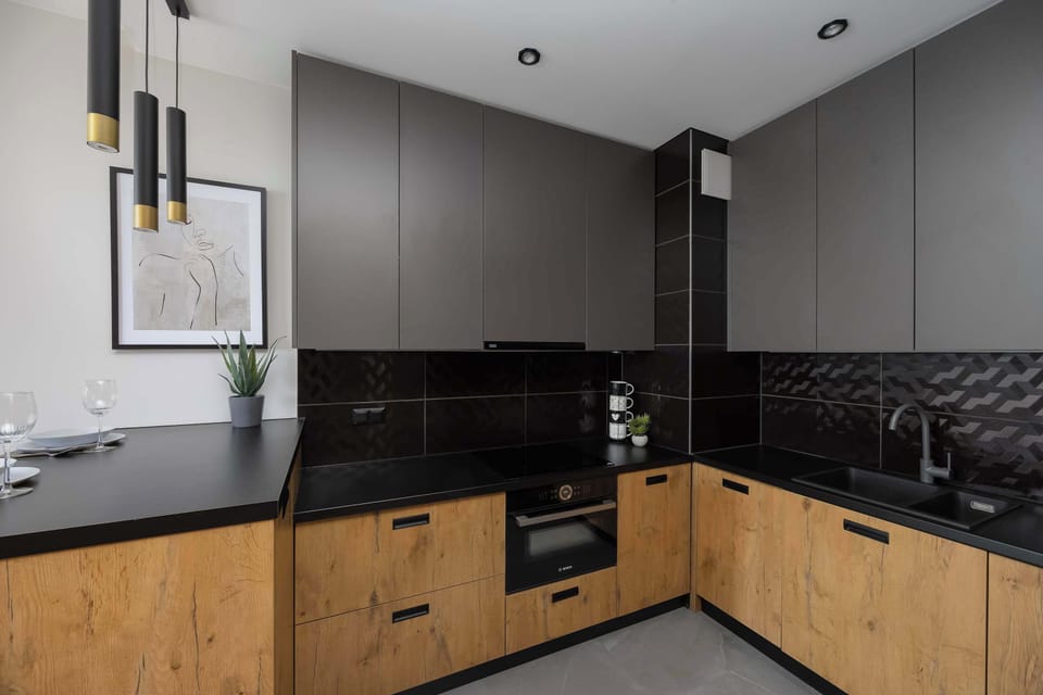 The kitchen workspace is well-lit with recessed ceiling lights, highlighting the clean lines of the induction cooktop.