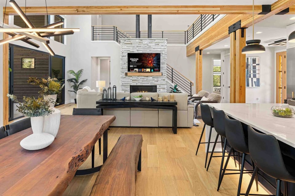 From the live-edge table you can see the fireplace, the loft, and the kitchen — nothing feels far away