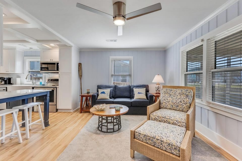 Relax in your bright, airy living space with coastal charm, modern ceiling fan, and open kitchen perfect for vacation meals.