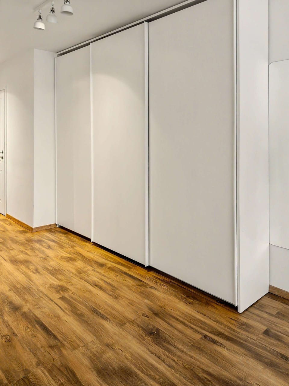 Bright and modern living area with warm wooden floors and minimalist design. A welcoming space to relax, unwind, or enjoy quality time in a cozy yet stylish setting.