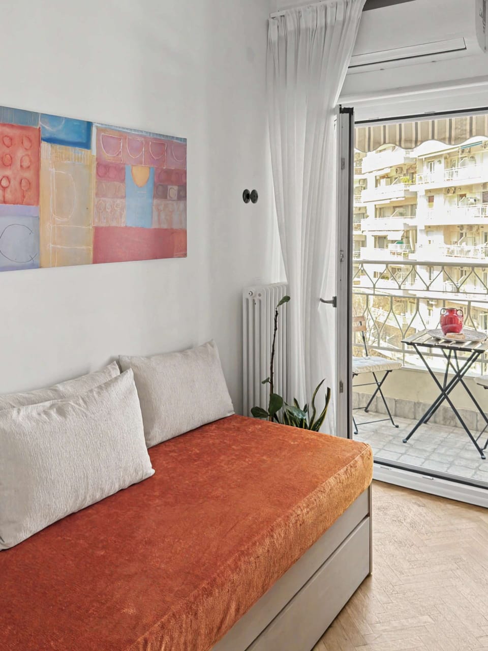 "Cozy up on this stylish daybed right next to the balcony. Flooded with natural light, it’s the ultimate spot to lounge, read a book, or plan your next city adventures."