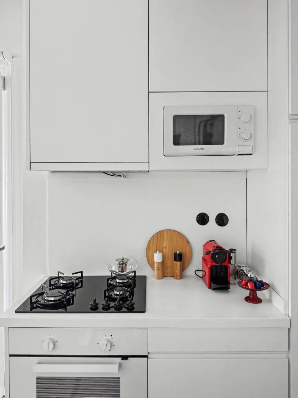 "Cook with ease in this fully equipped, contemporary white kitchen. Features sleek countertops, modern stove, and all essentials needed to whip up a delicious breakfast."