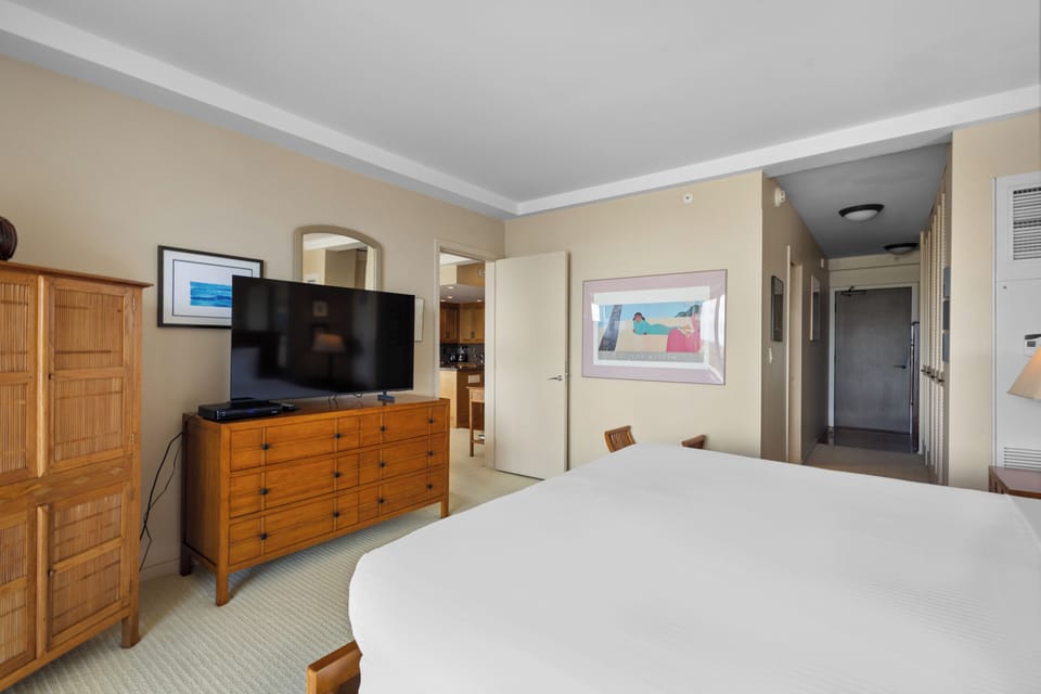 Rest in your serene bedroom with plush bedding, warm wood furnishings, and entertainment at your fingertips.