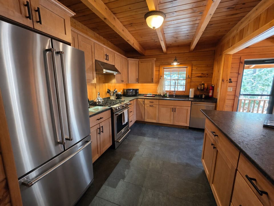 Spacious cabin kitchen with stainless steel appliances, granite countertops, and plenty of room for family meals.