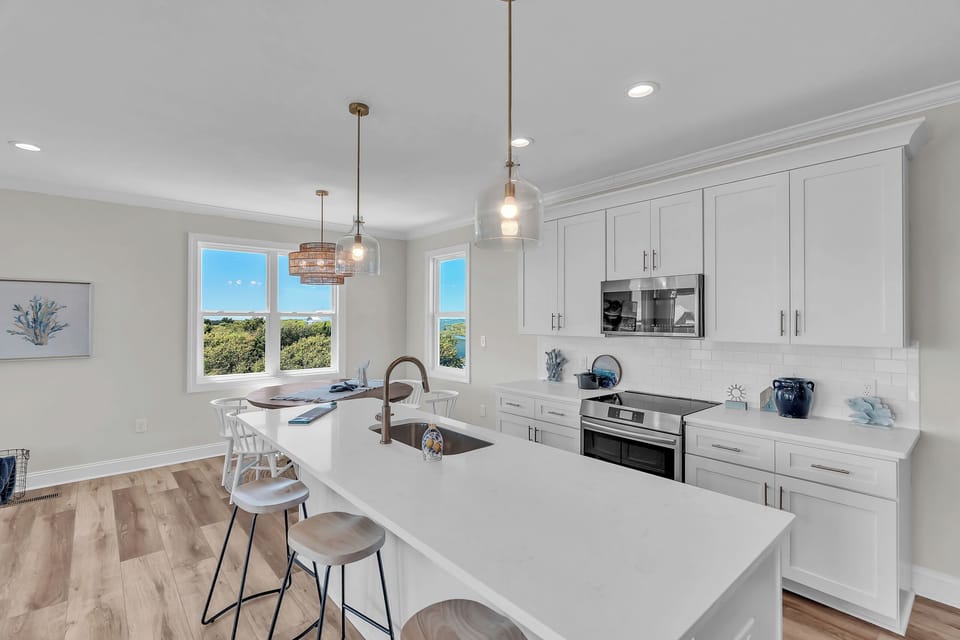 Step into your bright, modern kitchen with coastal views through large windows. Cook with joy using premium appliances and spacious countertops.