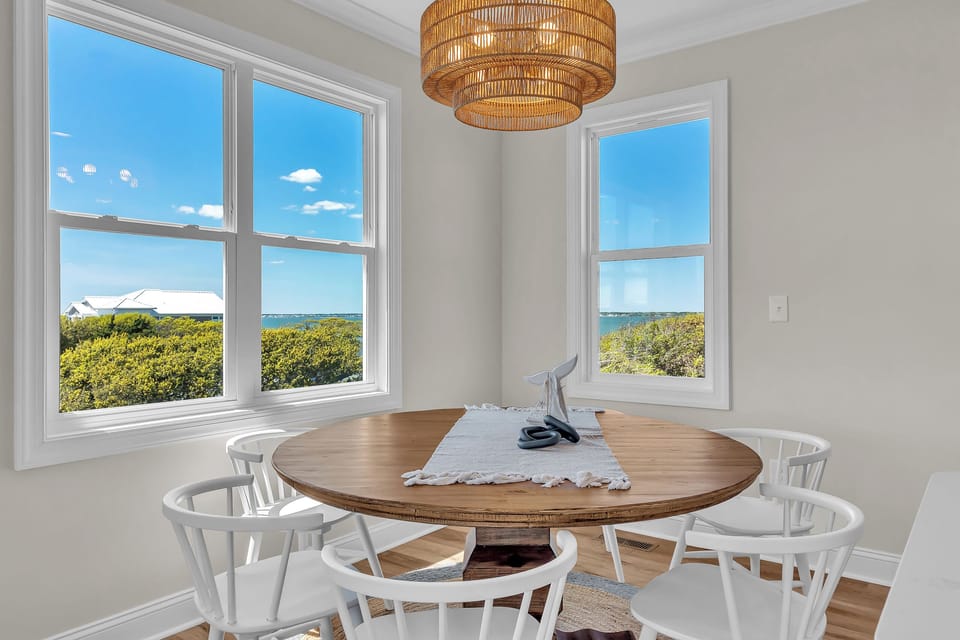 Picture yourself enjoying morning coffee at this sunlit dining table while ocean views stretch endlessly beyond your windows.