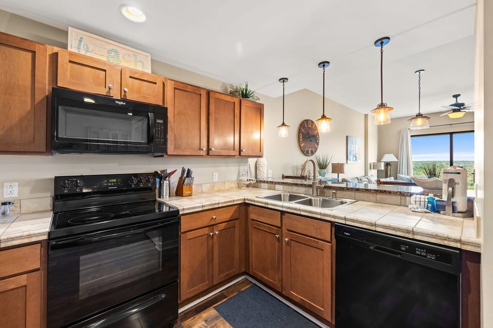 Your fully-equipped kitchen features granite counters, warm wood cabinets, and modern appliances for creating memorable meals together.