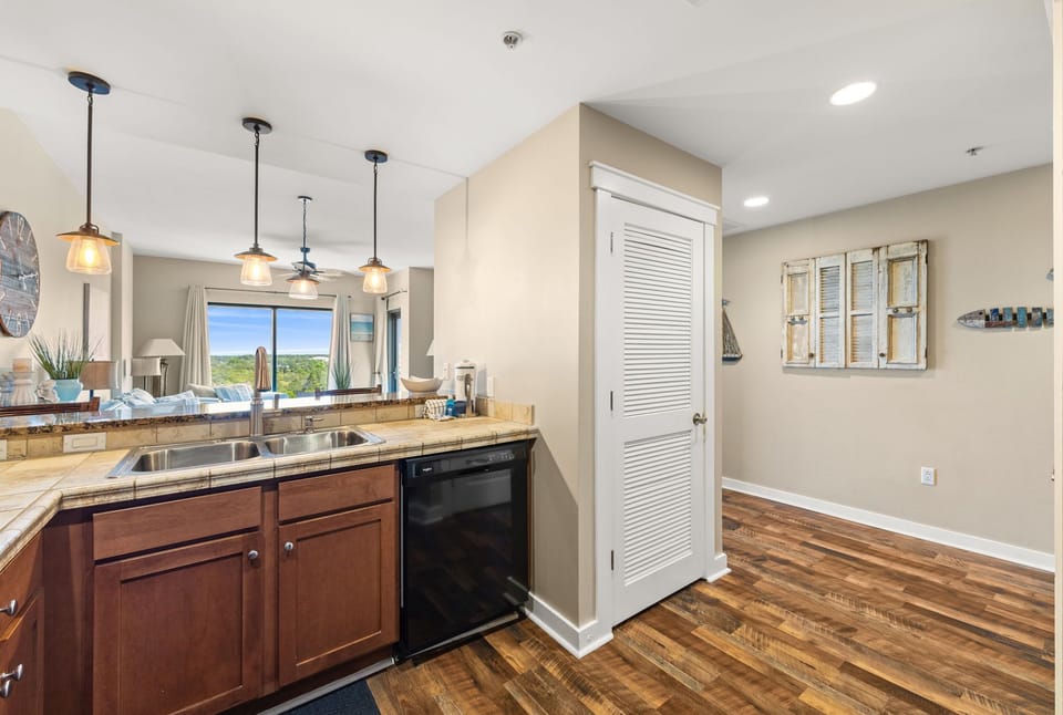 Cook with style in your modern kitchen featuring granite countertops, warm wood floors, and pendant lighting.