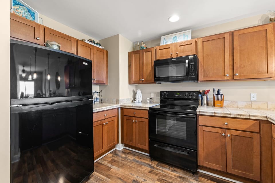 Cook your favorite meals in this fully equipped kitchen with modern appliances, warm wood cabinets, and ample counter space for all your culinary adventures.
