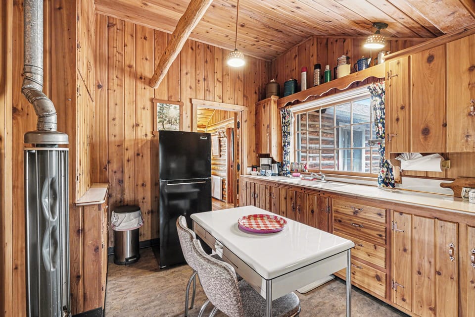 Cozy wood-paneled cabin kitchen with rustic charm throughout.