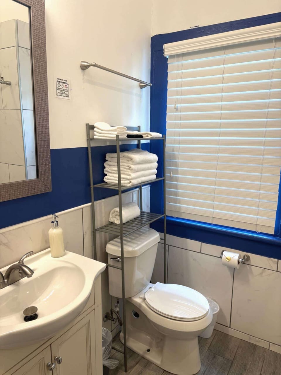 Compact full bathroom with bright accents, a vanity, and convenient shelving—everything you need in a clean, efficient space.