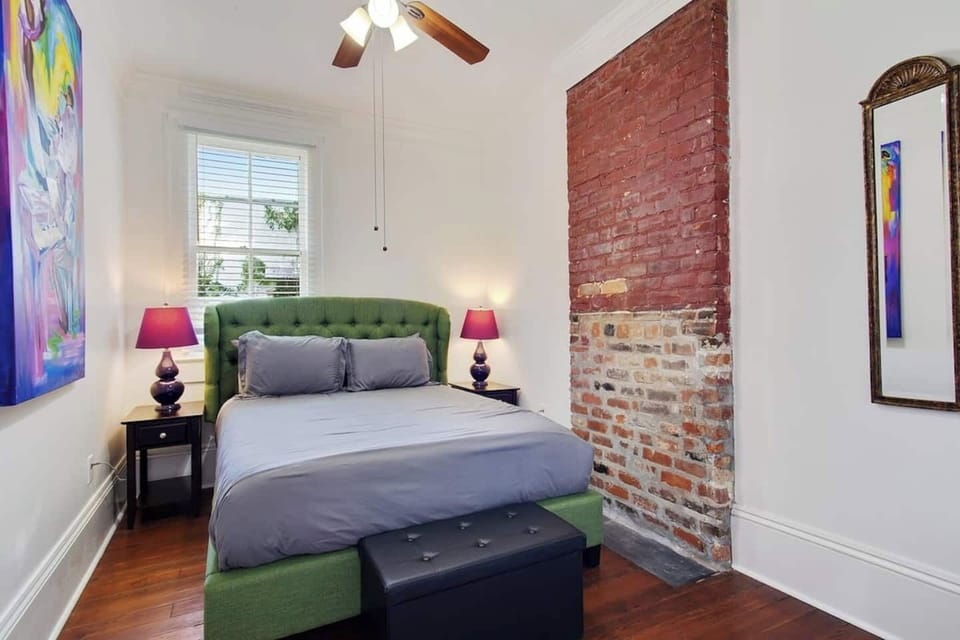Cozy bedroom with exposed brick accents and warm touches for a stylish, comfortable retreat.