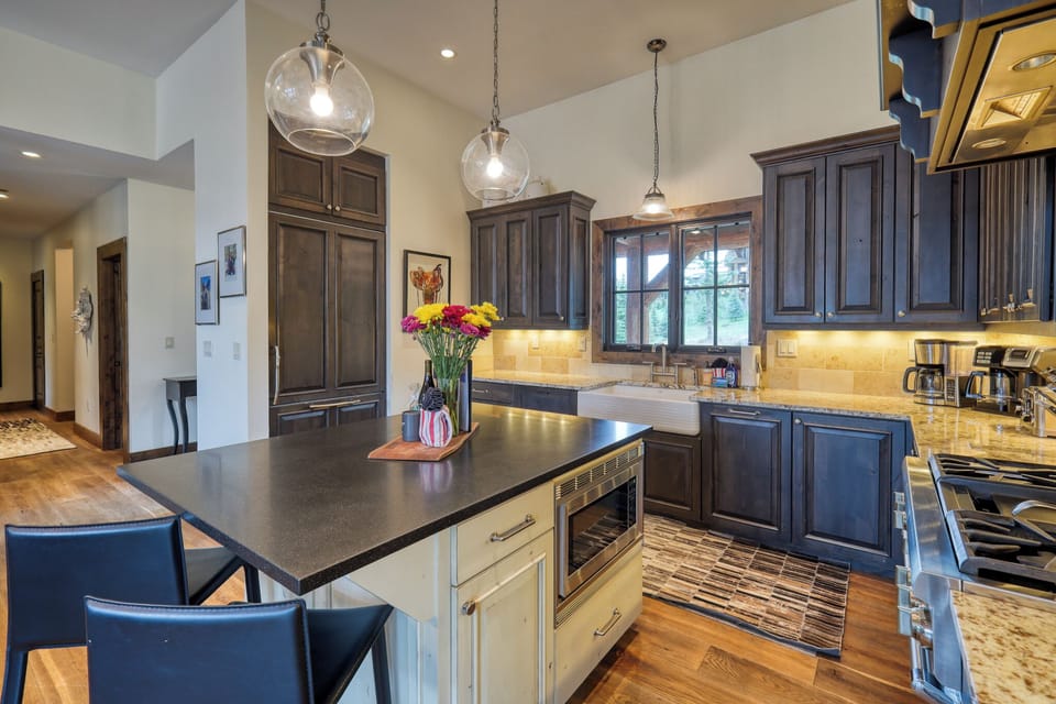 Create culinary memories in this spacious kitchen featuring granite countertops, modern appliances, and elegant pendant lighting for your cooking adventures.