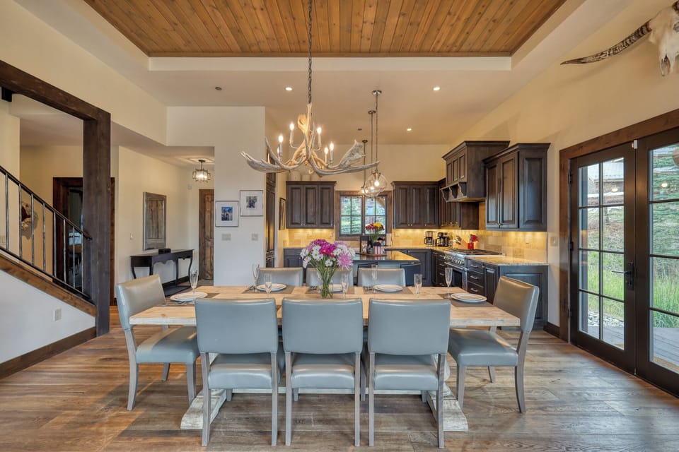 Gather around your spacious dining table beneath soaring wood ceilings and rustic chandeliers, where culinary memories unfold.