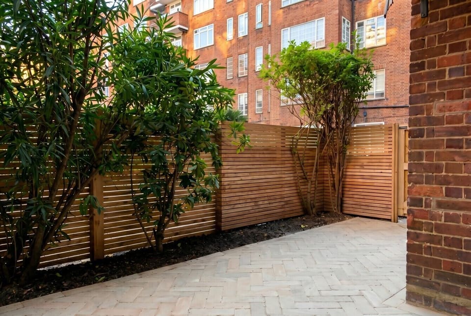 Private courtyard garden with lush planting and cedar slatted fencing for seclusion.