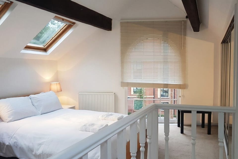 Exposed beams and a skylight give this mezzanine bedroom a quietly special feel.