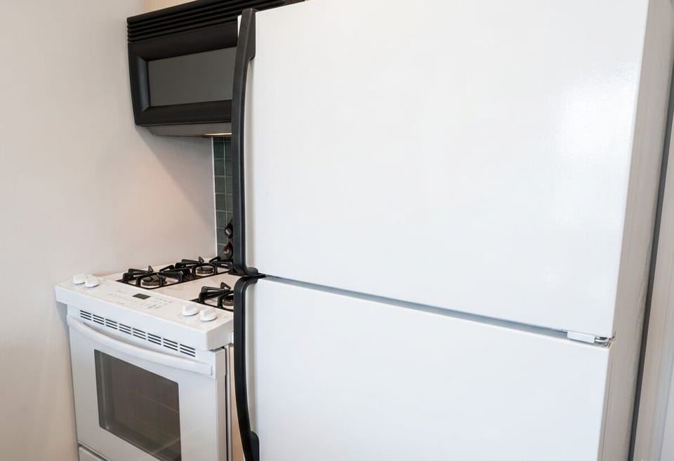 Modern kitchen equipped with a full size fridge, stove, oven, and microwave.