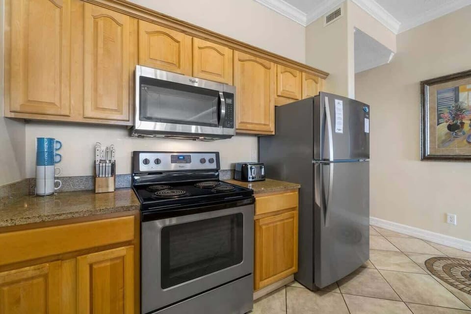 Fully Stocked Kitchen with Stainless Steel Appliances and Island Bar Seating
