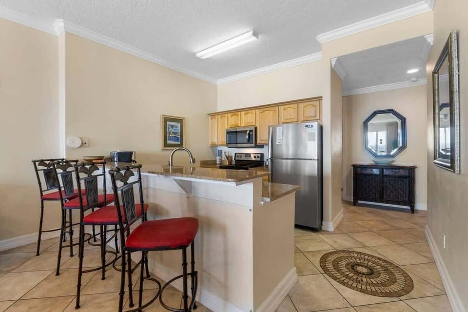 Fully Stocked Kitchen with Stainless Steel Appliances and Island Bar Seating