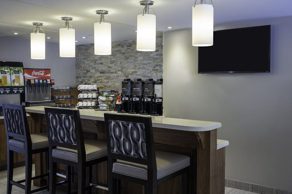 Breakfast bar with juice dispensers, a beverage station, and stone-wall surround — help yourself every morning as part of your stay.