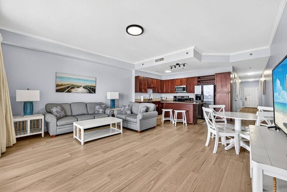 Bright and airy living space with dining area, queen sleeper sofa, and panoramic Gulf views.