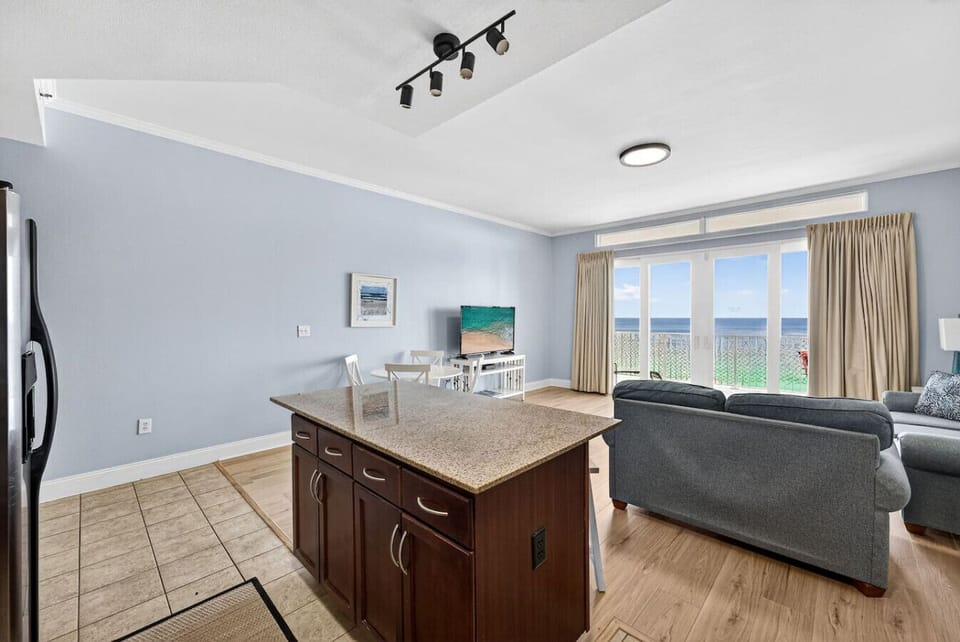 Open-concept kitchen and living area with island seating and Gulf views.