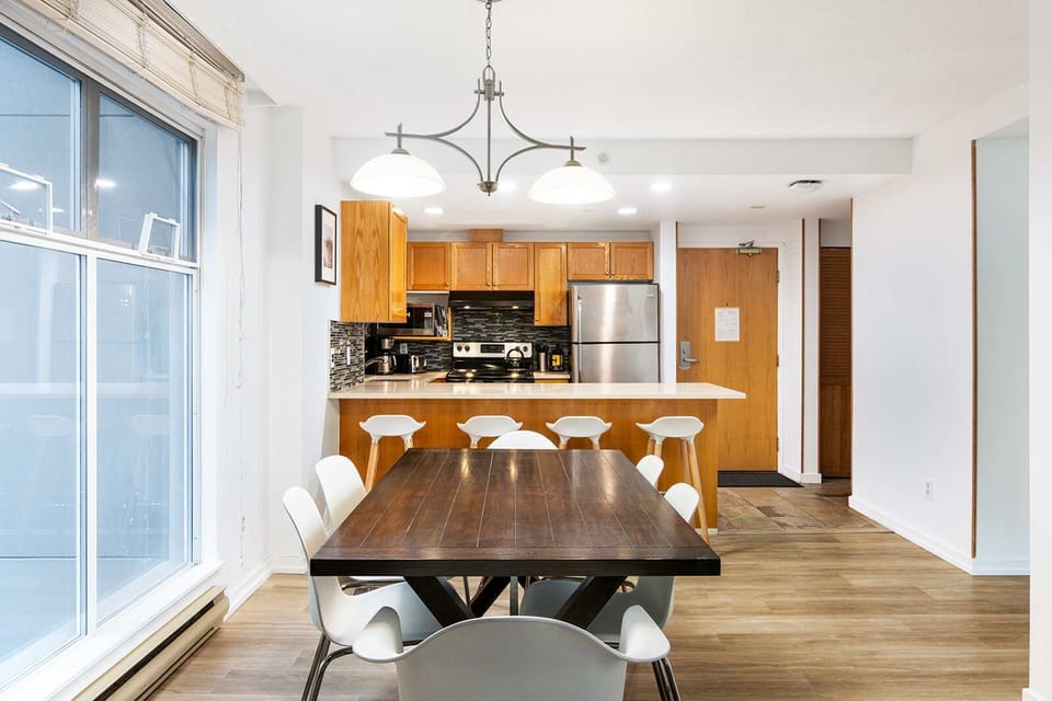 - Open-concept kitchen and dining area perfect for shared gatherings - Modern lighting and sleek finishes create a warm inviting flow - Ideal setup for family meals or group get-togethers after mountain fun