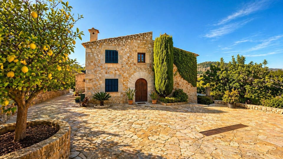 Stone facade of the finca with patio and fruit trees in Pollensa