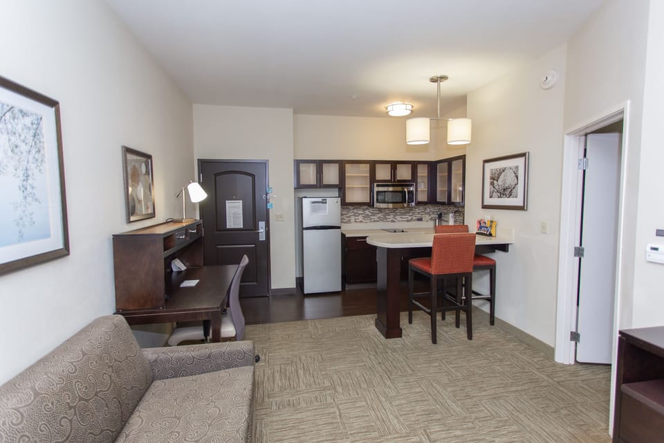 Open living area with sofa, desk, and kitchen.