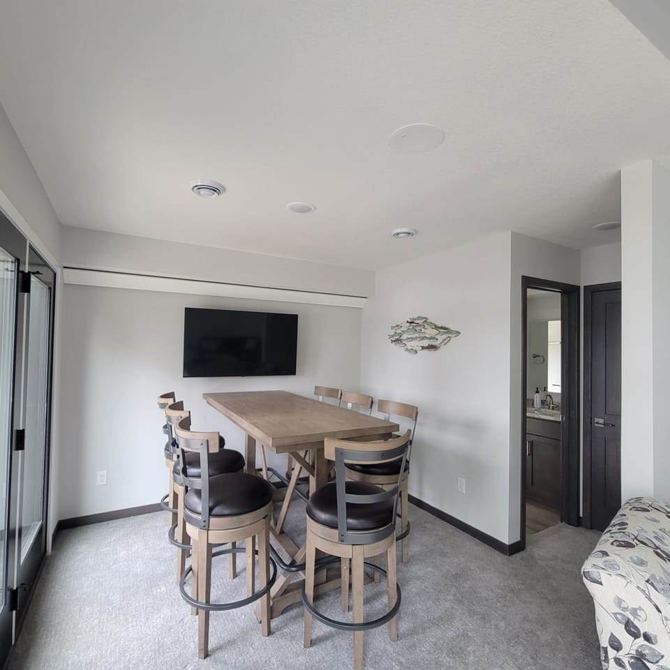 Maybe level living room with 2 TVs and table for gathering.