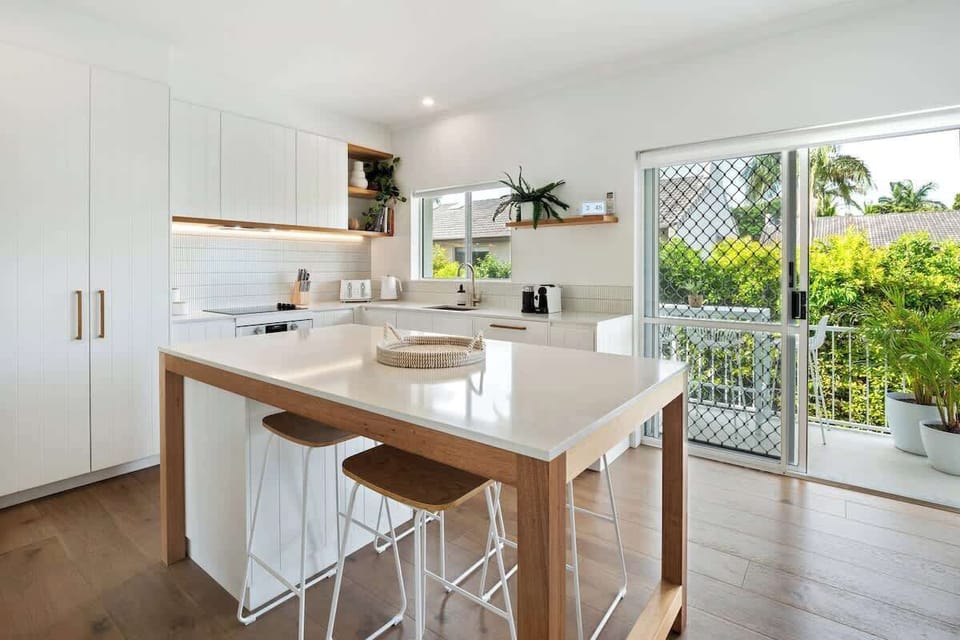 The kitchen includes a semi-island dine-up/breakfast bar, stone bench tops.