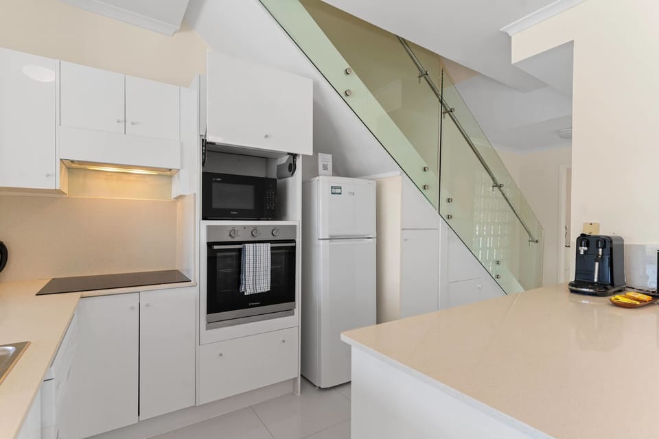 The kitchen retreat presents streamlined cabinetry, full cooking amenities, and generous bench space for effortless holiday meal preparation.