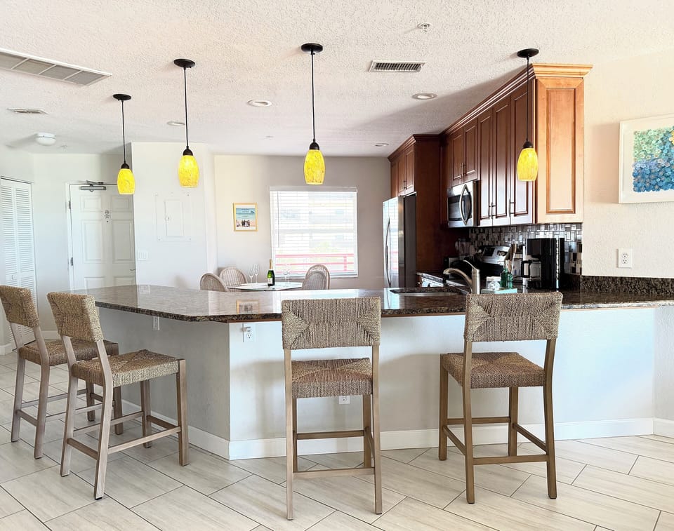 Bar seating. Wine & champagne glasses. Electric stove. Fridge with ice maker