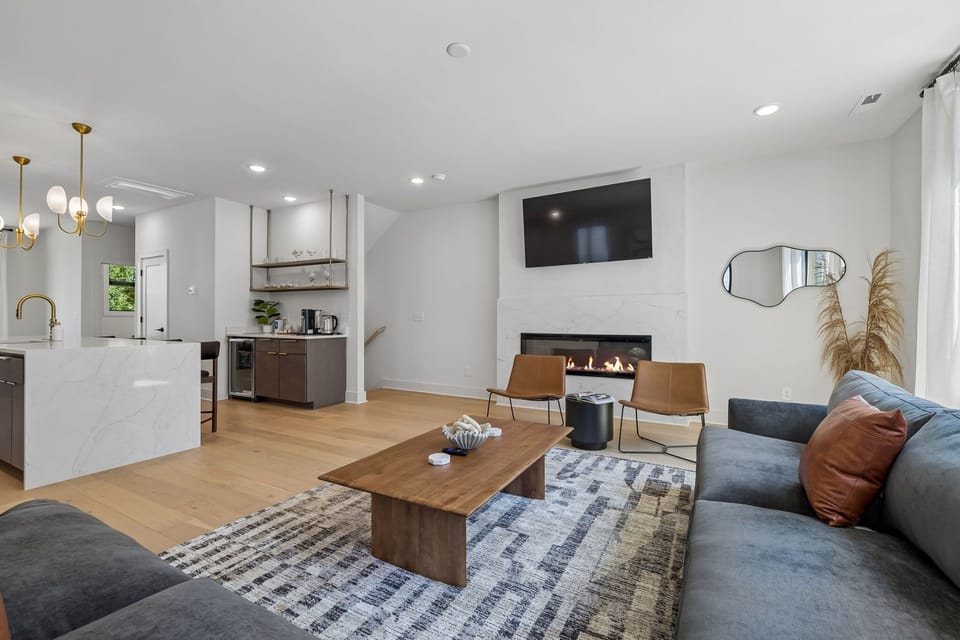 Living Room: The heart of the home — a warm, inviting living room with a fireplace, Smart TV, and sofa seating perfect for unwinding between Nashville adventures.