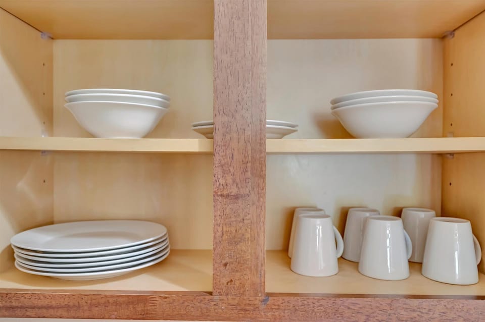 Kitchen cabinet stocked with plates and bowls