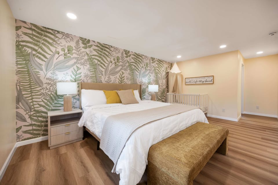 A serene sanctuary for the whole family: soft linens, calming greenery, and a gentle crib setup make bedtime a breeze.