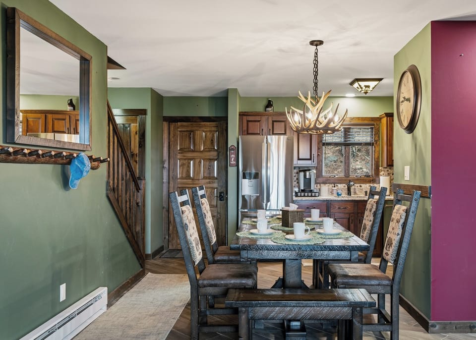 Warm, cabin‑style kitchen and dining area with wood accents, modern appliances, and a cozy open layout.