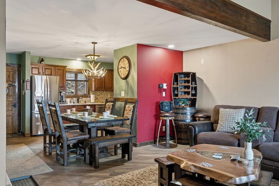Warm, rustic open layout with a cozy living area, wood‑accent kitchen, and a welcoming dining table.