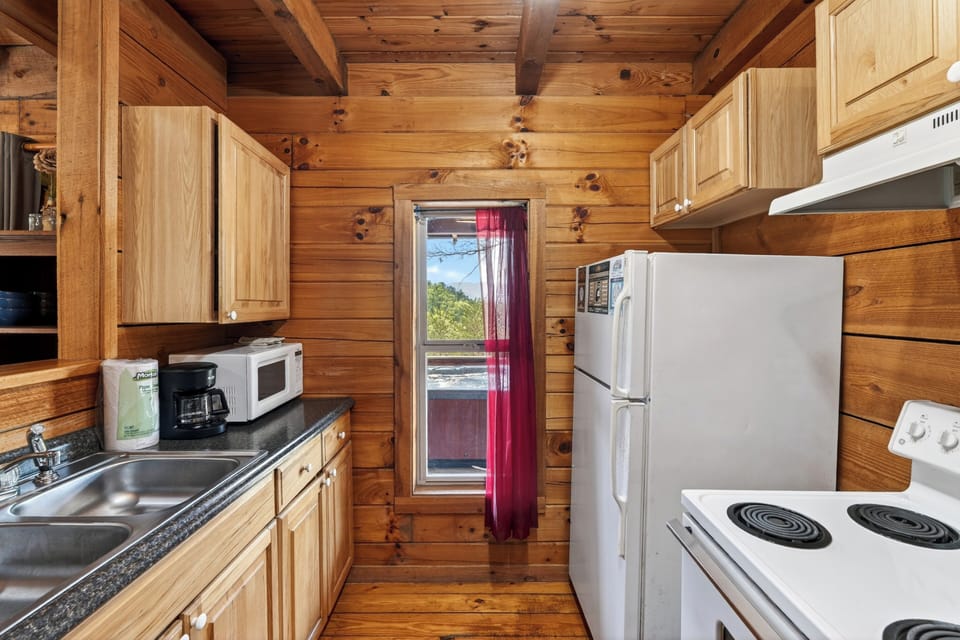Warm wood‑planked cabin kitchen with simple essentials, soft natural light, and a cozy rustic charm.