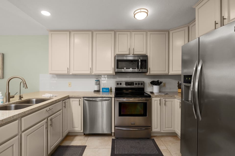 Fully stocked kitchen with stainless appliances and prep space