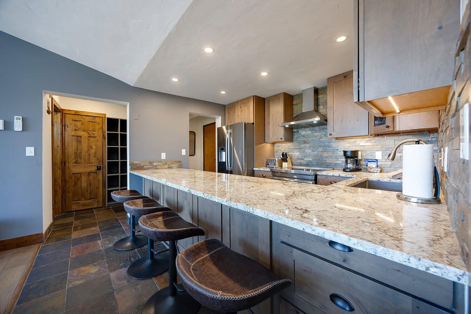 Gather around this stunning granite island where you'll create memories over morning coffee and late-night conversations in your fully equipped kitchen.