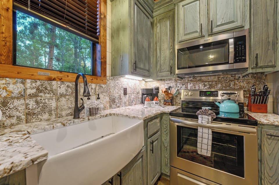 You'll love cooking in this beautifully appointed kitchen with stunning marble countertops and charming forest views.