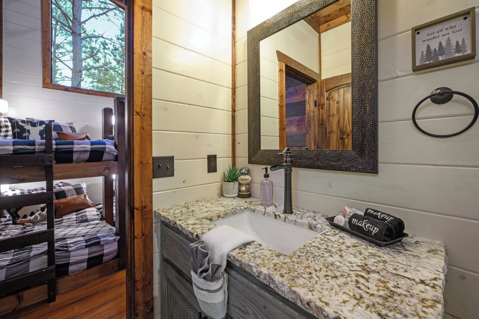 Freshen up in your private bathroom featuring granite countertops and rustic charm, with bunk bed rooms just steps away.