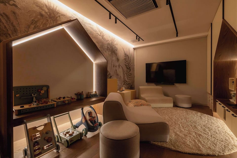 A modern kids area with curved seating, soft lighting, and a built-in TV wall. The design feels luxurious and inviting.