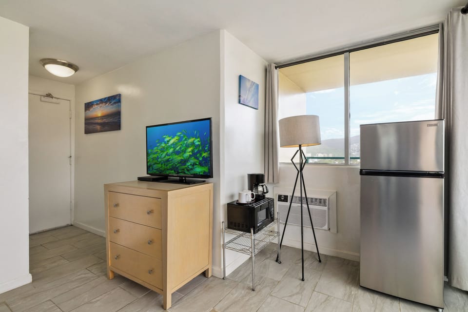 Your modern studio features everything needed for a comfortable stay - full-size fridge, microwave, coffee maker, and entertainment center with city views.