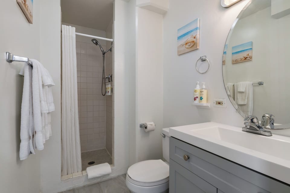 Freshen up in your bright, coastal-themed bathroom with walk-in shower and thoughtful touches like beach artwork to keep your vacation vibes flowing.