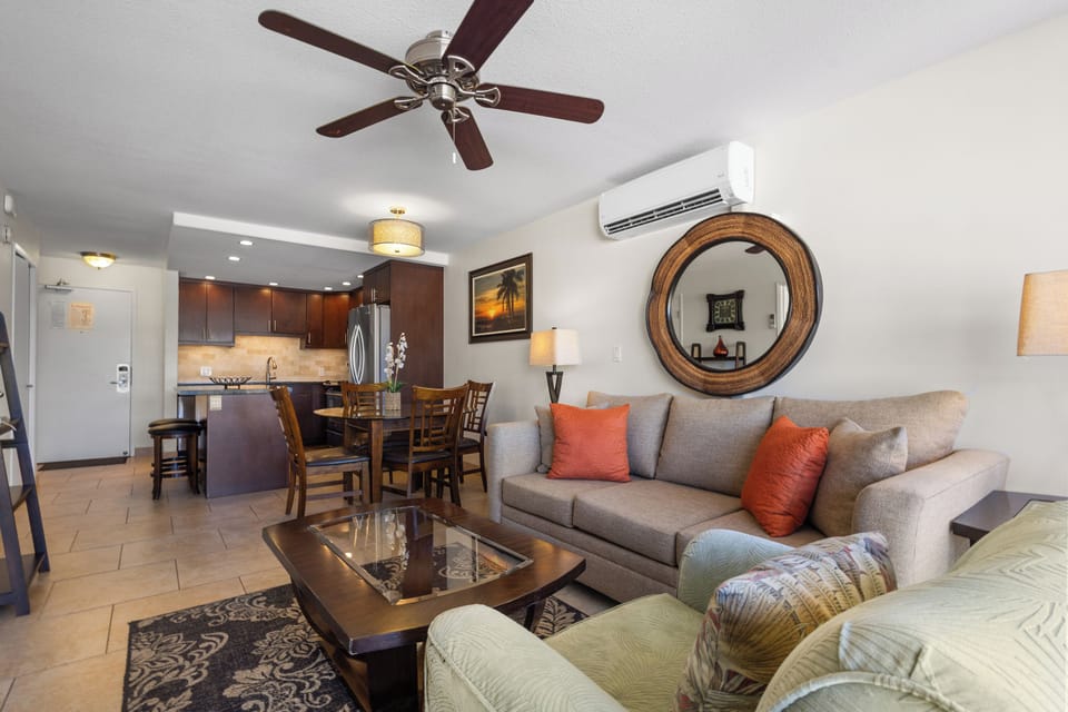 Relax in your stylish living space with plush seating, ceiling fan, and modern kitchen just steps away.