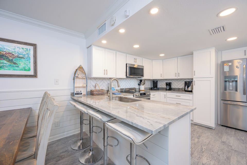 Bright kitchen invites you to sip morning coffee at the breakfast bar while the daylight fills the space