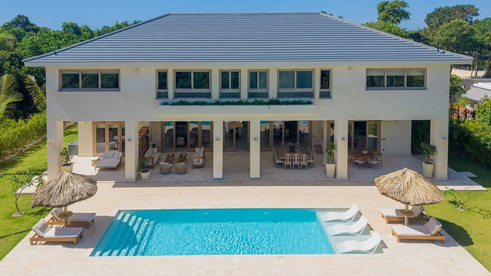 Spacious terrace with outdoor dining, lounge areas, and pool views