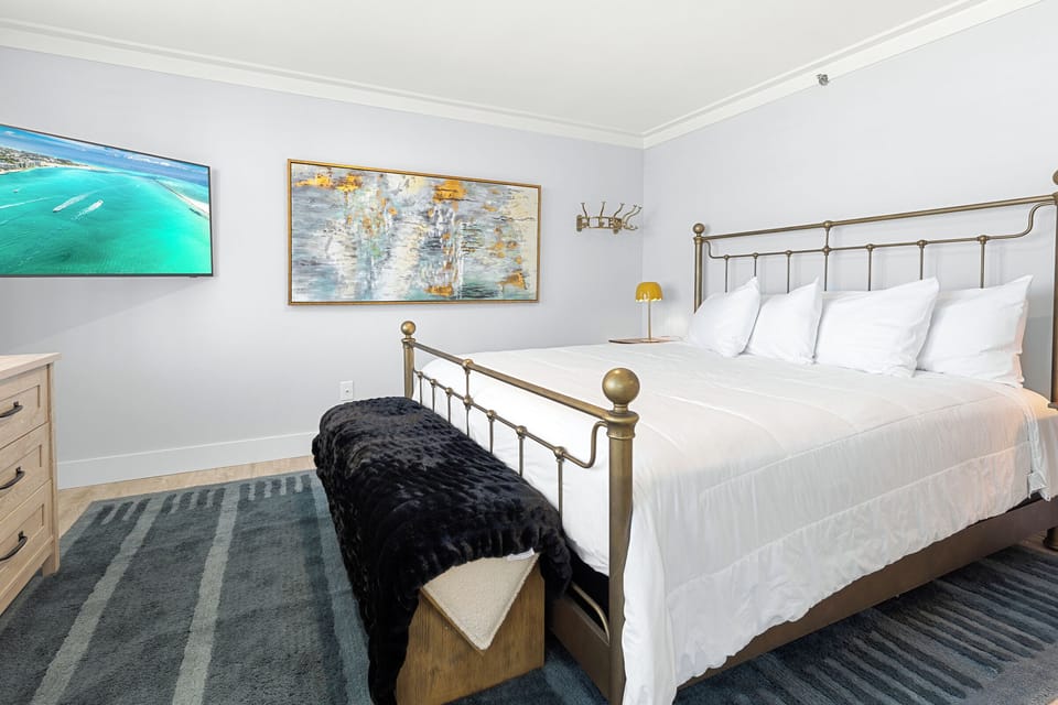 Drift off to sleep surrounded by coastal artwork and crisp white linens in your elegantly appointed bedroom.